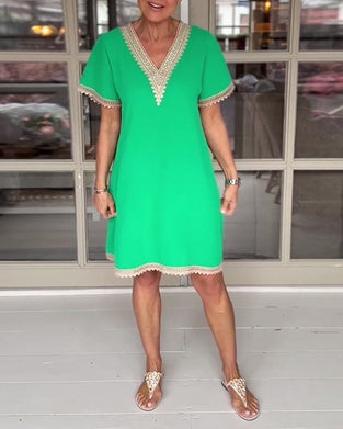 Elegant kjole med blondepaneler og V-udskæring