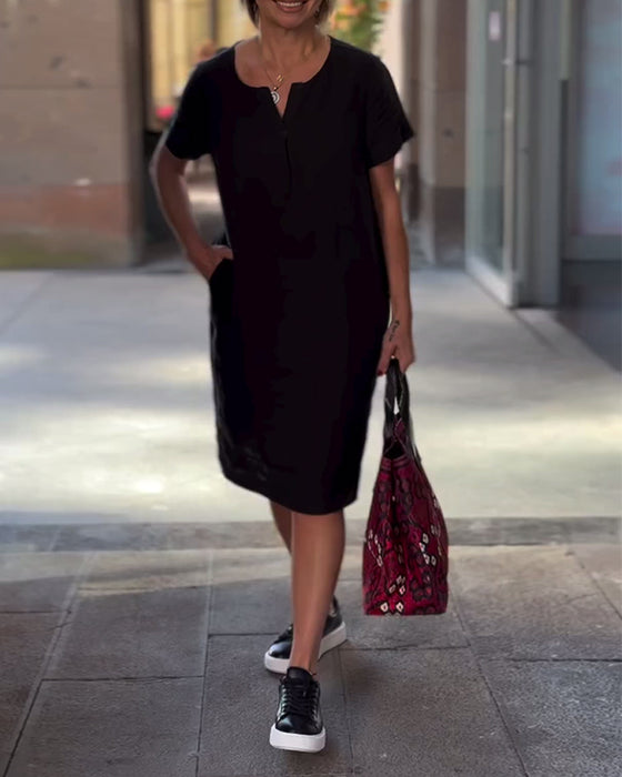 Kortærmet sort kjole med V-udskæring og lommer