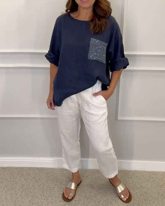 Rundhalset top med pailletdekoreret brystlomme