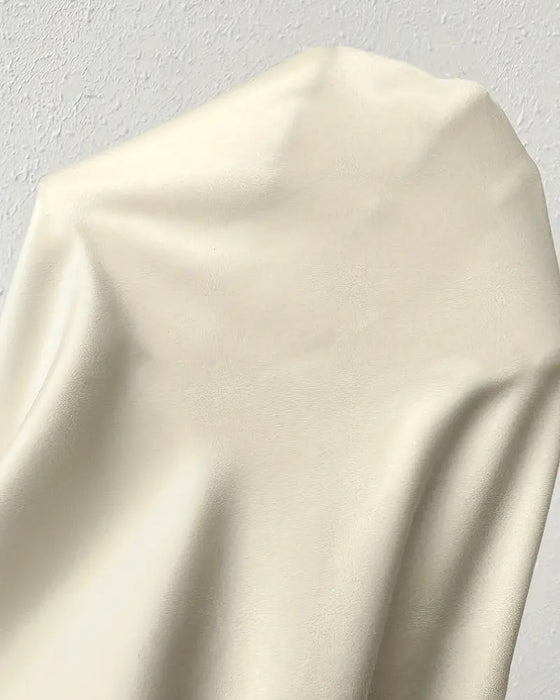 Ensfarvet bluse med flæser i uregelmæssig længde