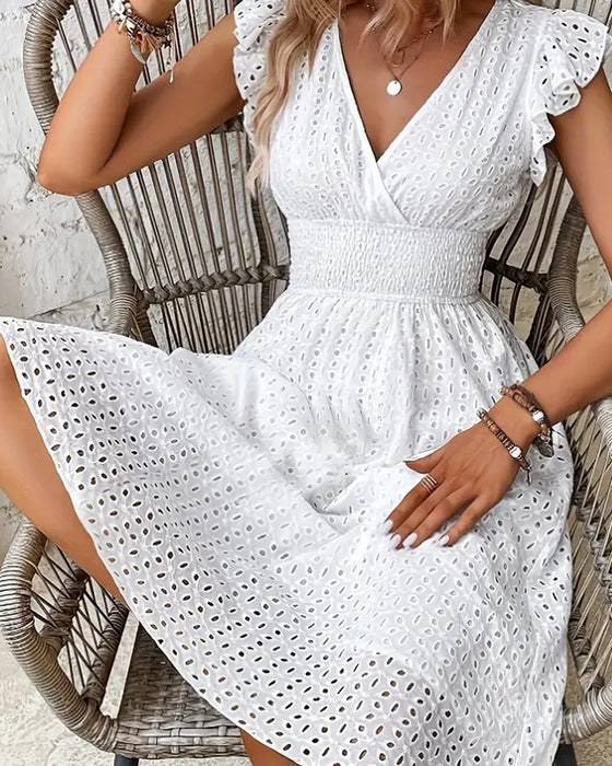 Hvid kjole uden ærmer med dyb V-udskæring og indsnævret talje