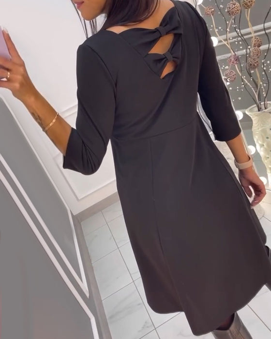 Ensfarvet kjole med sløjfer bagpå