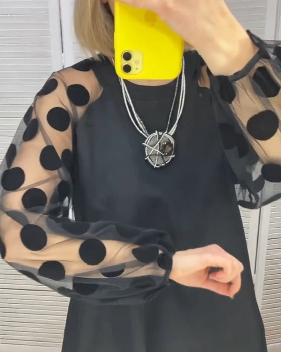 Sort kjole med prikmønstrede net ærmer