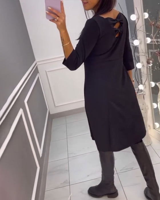 Ensfarvet kjole med sløjfer bagpå